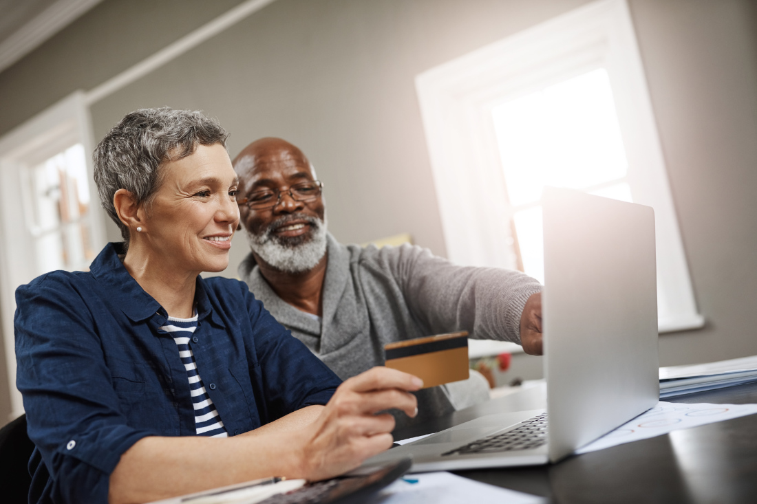 Women and man on laptop with debit card
