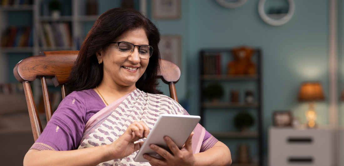 Lady smiling whilst on computer tablet