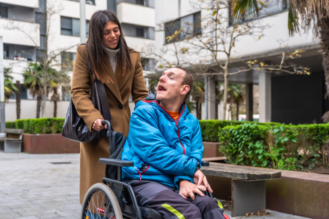Carer pushing a man in a wheelchair
