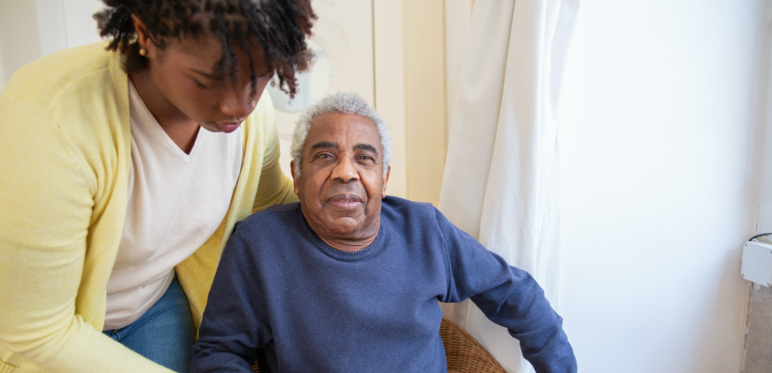 Male with carer receiving help whilst sat down